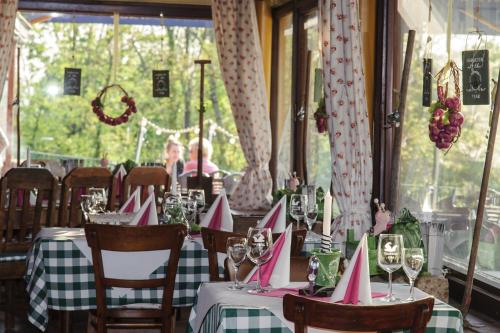 巴登-巴登Hotel Merkurwald - Restaurant Wolpertinger的用餐室配有带粉色纸帽的桌子