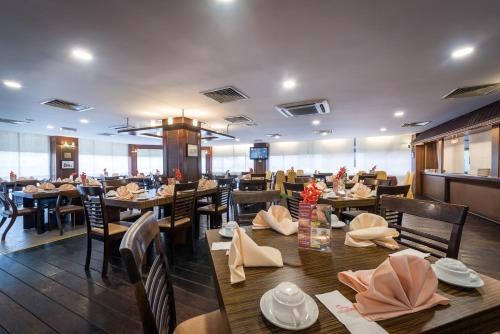 马六甲马六甲江景仙特拉酒店的用餐室配有木桌和椅子