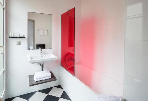 巴黎巴黎伏吉拉尔酒店的一间带水槽和红色镜子的浴室