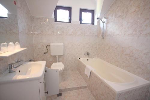 波亚纳布拉索夫鲁亚酒店的带浴缸、卫生间和盥洗盆的浴室