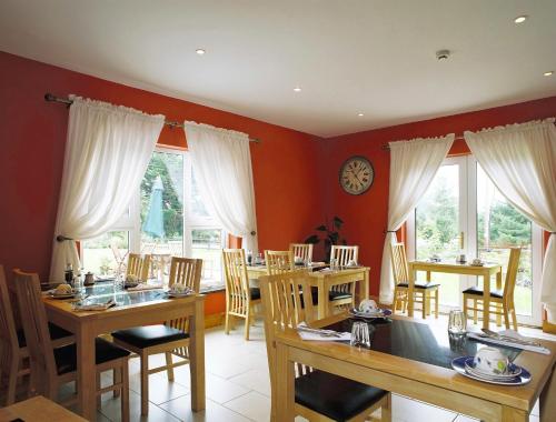 利敦瓦纳格林拉翁住宿加早餐旅馆的一间设有桌椅的用餐室和墙上的时钟
