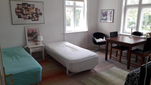 哥本哈根床和淋浴住宿加早餐旅馆的一间卧室配有一张床、一张桌子和一张桌子