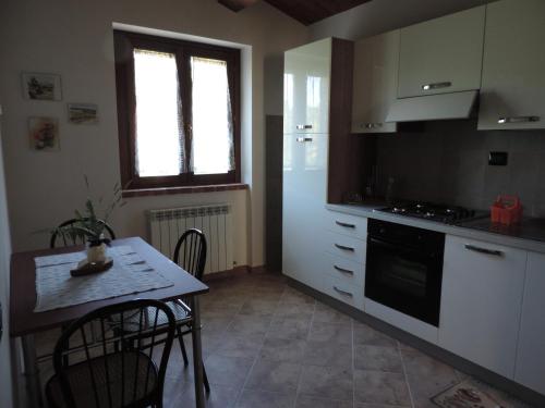 科玛南扎Il Gelso Rosso的带小桌子的厨房和带炉灶的厨房
