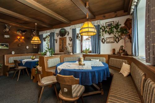 蒂罗尔州奥伯恩多夫Kaiserpension Müllnerhof的用餐室配有2张桌子和椅子以及灯光