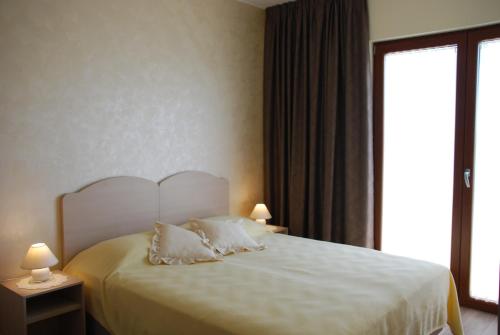 乌马格Rooms Edda的一间卧室配有一张带白色床单的床和一扇窗户。