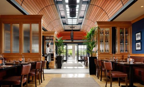 特拉利Ballygarry Estate Hotel & Spa的餐厅设有木制天花板和桌椅
