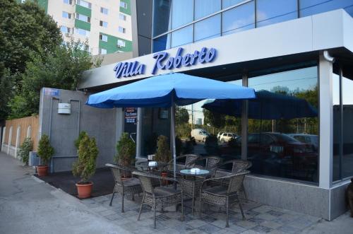 康斯坦察罗伯托别墅酒店的餐厅前的桌椅和遮阳伞