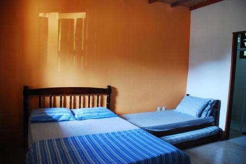乌巴图巴Chalés na Mata Ubatuba的一间卧室配有两张床和椅子