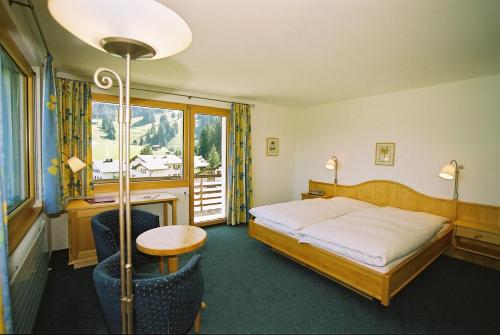 帕尔潘阿尔皮纳巴班酒店的一间卧室配有一张床、一张桌子和一个窗户。
