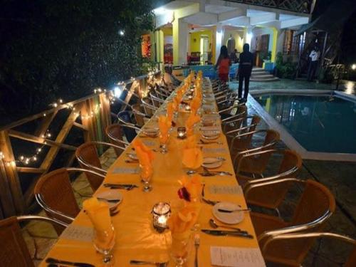 安东尼奥港湾景生态水疗度假酒店的游泳池旁带盘子和酒杯的长桌