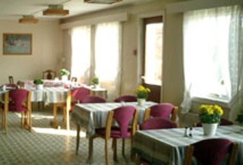 特韦德斯特兰斯捷威斯托度假酒店的餐厅设有桌子、紫色椅子和窗户