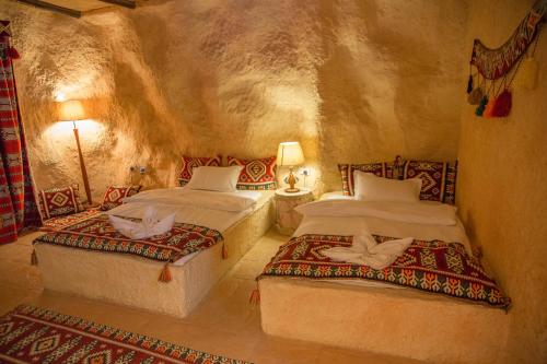 MaḩḑahWadi Sharm Resort的石头客房设有一间带两张床的卧室