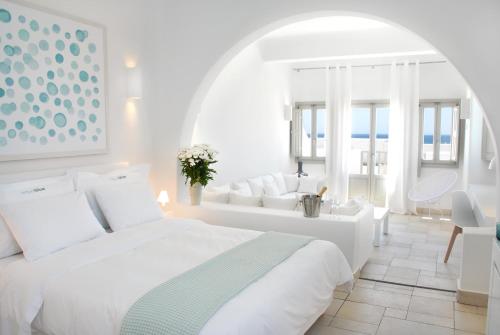 佩里萨水蓝色海滩酒店的一间白色的卧室,配有床和客厅