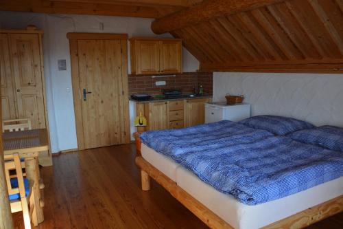 普拉哈季采查鲁帕安布拉山林小屋的一间卧室配有一张带蓝色棉被的床