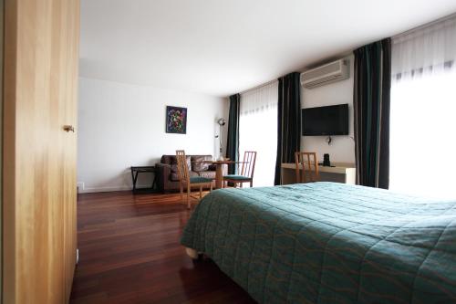 皮蒂维耶斯卡拉酒店的一间卧室配有一张床,客厅配有桌子