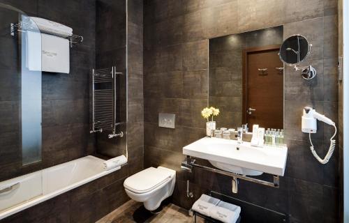 毕尔巴鄂库里森斯考特尔酒店的浴室配有盥洗盆、卫生间和浴缸。