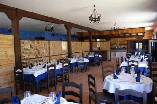 Navas de Estena林斯特加贝内罗斯乡村民宿 - 乡村旅游中心的一间配备有桌椅及蓝餐巾的用餐室
