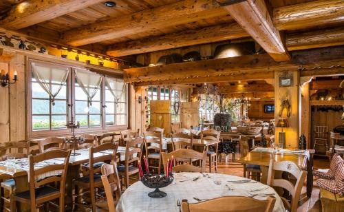 克松吕-隆日梅领小屋酒店的一间设有桌椅的餐厅,位于带木制天花板的房间内