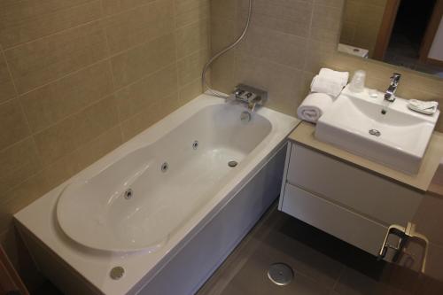 纳扎雷Apartamentos Turisticos da Nazare的带浴缸和盥洗盆的浴室