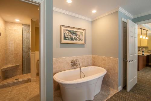 林肯RiverWalk Resort at Loon Mountain的带淋浴的浴室内的白色浴缸