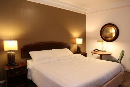 伯克利纳什酒店的一间卧室配有一张床、两盏灯和一面镜子