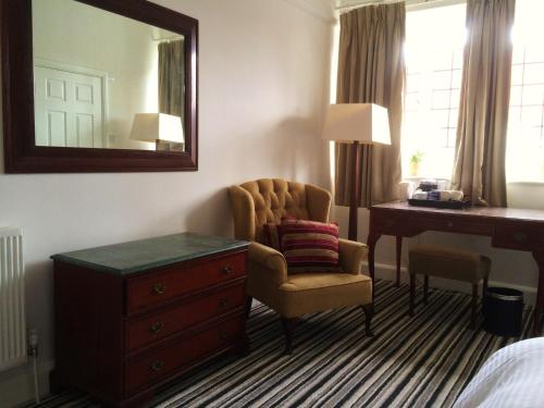唐克斯特INGRAM ARMS HOTEL, HATFIELD的酒店客房配有椅子、书桌和镜子
