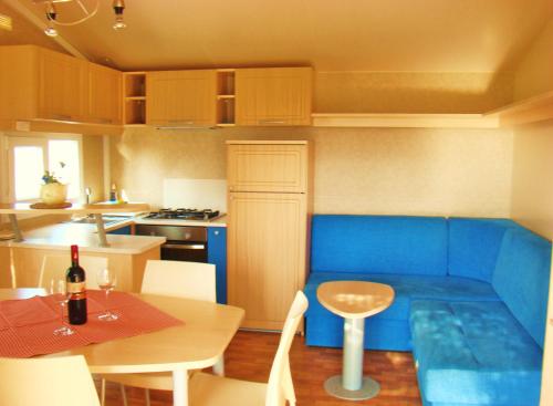 ŠempasMobilehouse & Camping Lijak的一间厨房,内设蓝色的沙发和一张桌子