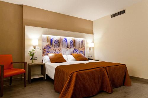 格拉纳达Porcel Sabica的酒店客房,配有床和橙色椅子