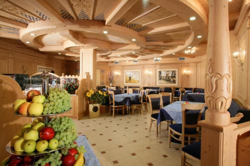 安达洛罗察加尼酒店的用餐室配有桌椅和水果展示