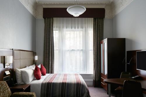 伦敦特拉法加广场豪华酒店的酒店客房设有床和窗户。