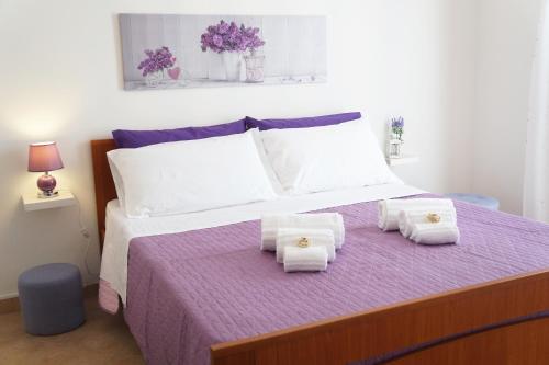 库斯托纳奇Casa Vacanza da Rosa的一间卧室配有一张大床和毛巾