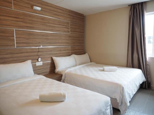 怡保晨星酒店@怡保东区的酒店客房设有两张床和窗户。