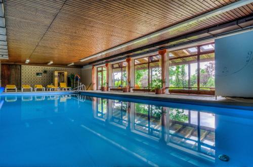 瓦门施泰纳赫WAGNERS Hotel im Fichtelgebirge的蓝色的游泳池和窗户