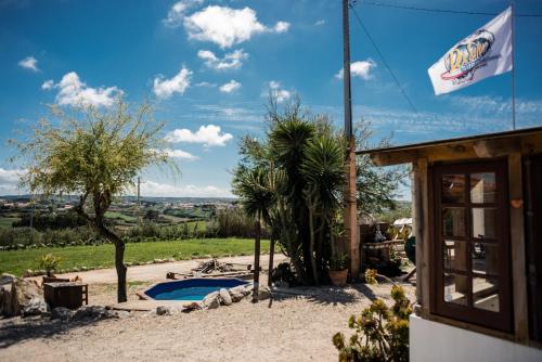 阿雷亚布兰卡Da Silva Surfcamp的一座带游泳池和国旗的房屋