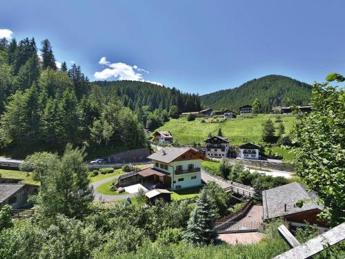 奥贝雷根Rider Hotel Obereggen的山中的一个村庄,有房子和树木