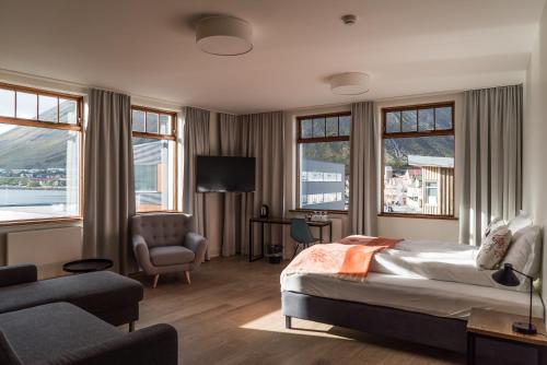 伊萨菲尔德Hotel Isafjordur - Horn的一间卧室配有一张床、一把椅子和窗户。