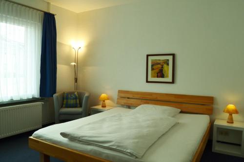 魏豪森魏豪森啤酒坊酒店的卧室配有床、椅子和窗户。