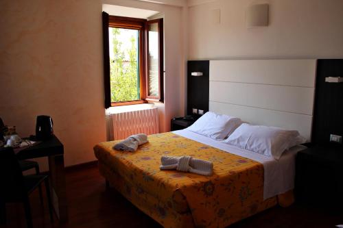佩鲁贾普瑞玛维拉迷你酒店的一间卧室配有一张带黄色毯子和窗户的床
