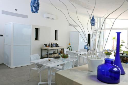 特拉尼拉贝拉特拉尼住宿加早餐旅馆的一间设有白色桌椅和蓝色花瓶的房间