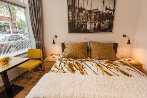 格罗宁根Lutje Kerklaan的一间卧室配有一张床、一张桌子和一个窗户。