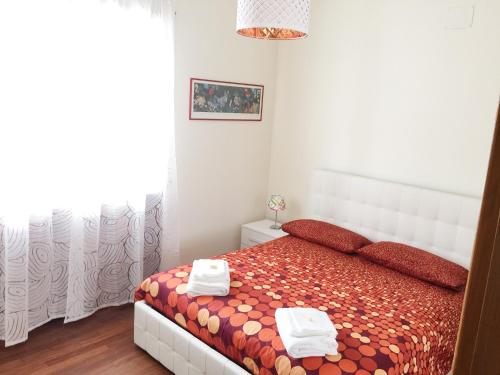 罗马特纳利夫岛罗马套房公寓的一间卧室配有一张床,上面有两条毛巾
