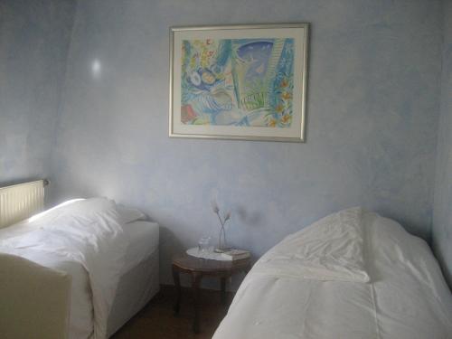 巴黎52 Clichy Bed & Breakfast - Chambre d'hôtes的卧室配有两张床,墙上挂着一幅画