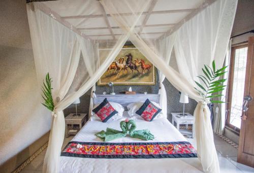 佩母德兰Global Lodge Pemuteran的一间卧室配有一张带天蓬的床
