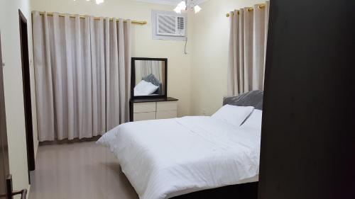 塞拉莱Golden Seasons Furnished Apartment - 2的卧室配有白色的床和镜子