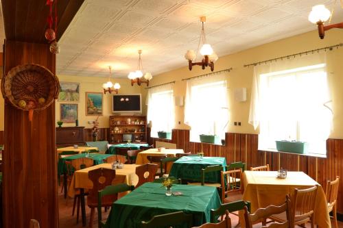 多克西丝克尔卡膳食公寓的一间带桌子和绿桌布的用餐室