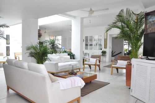 卡塔赫纳Penthouse Caribbean View and private pool, Cartagena的客厅配有白色家具和棕榈树