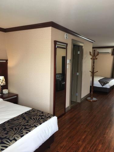 New Minas格林斯博罗酒店的酒店客房设有一张床,墙上有十字架
