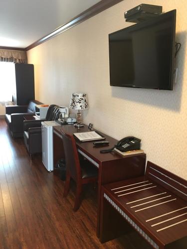 New Minas格林斯博罗酒店的酒店客房配有桌椅和平面电视。