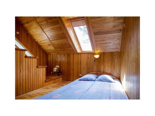 内林加Forest Cottage的木制客房内的一间卧室,配有一张床