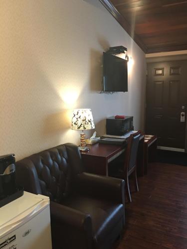 New Minas格林斯博罗酒店的一间配有沙发、一张桌子和一台电视的酒店客房